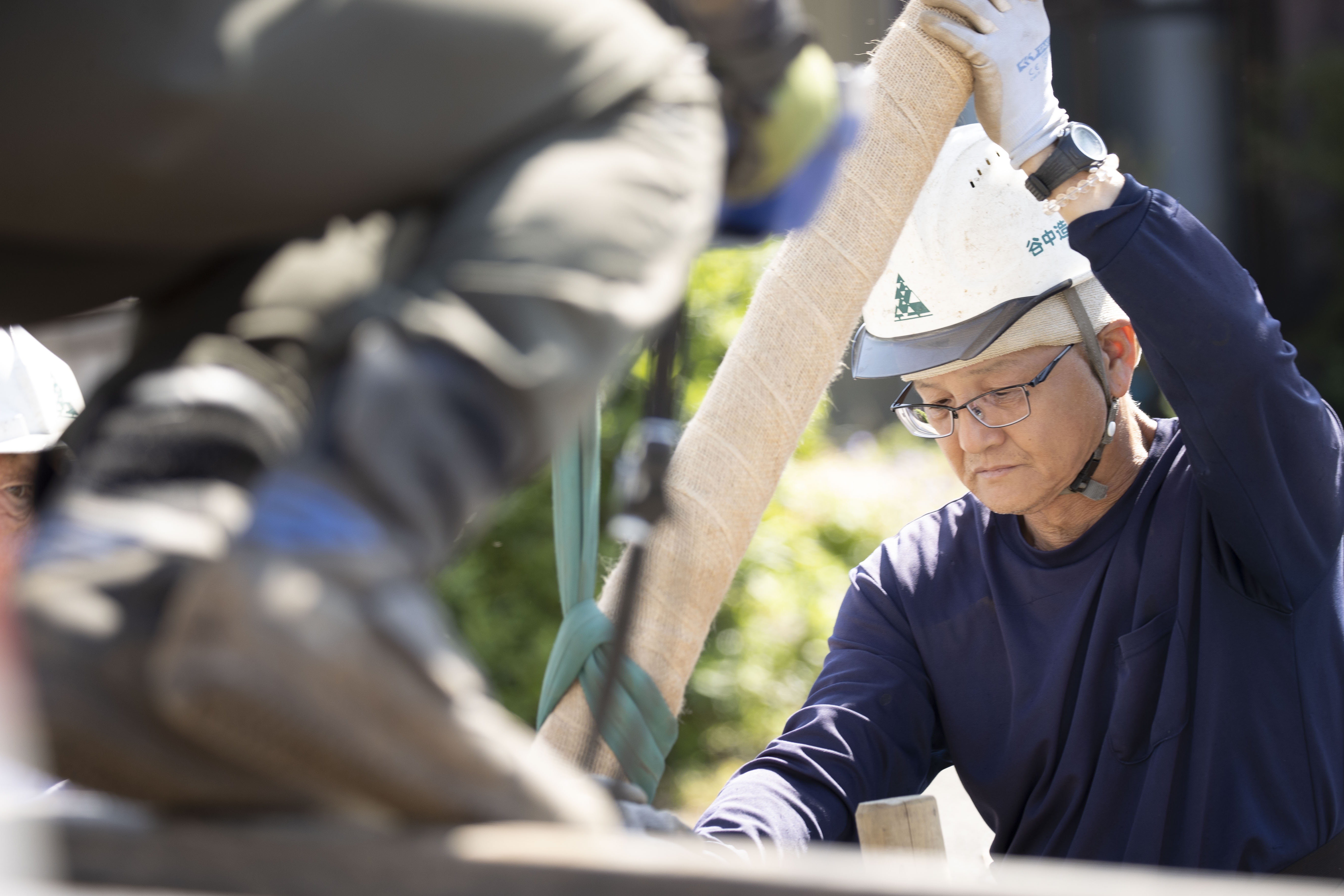 植栽する樹木を支えながら作業に取り組むスタッフ